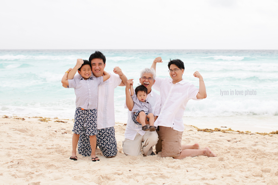 Asian family portraits on the beach in white outfits and strong men in Cancun, Mexico, by Lynn in Love Photo, Dallas Family Photographer